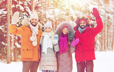 Image showing group of friends waving hands in winter forest