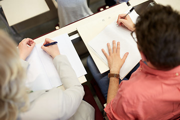 Image showing students writing to notebooks at exam or lecture