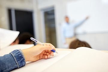 Image showing student hand writing to notebook at lecture