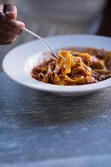 Image showing a young African American woman eating pasta