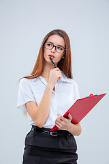 Image showing The young business woman with pen and tablet for notes on gray background