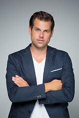 Image showing Portrait of a smart young man standing with arms crossed.