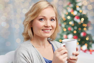 Image showing happy woman with cup of tea or coffee at christmas