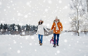 Image showing happy family with sled walking in winter outdoors