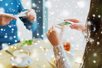 Image showing close up of couple picturing food by smartphone