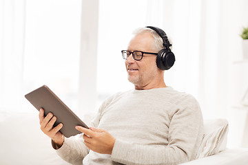 Image showing senior man with tablet pc and headphones at home