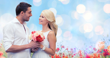 Image showing happy couple with flowers over lights background