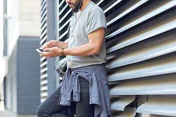 Image showing man with earphones, smartphone and bag on street