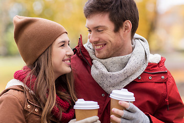 Image showing happy couple with coffee walking in autumn park
