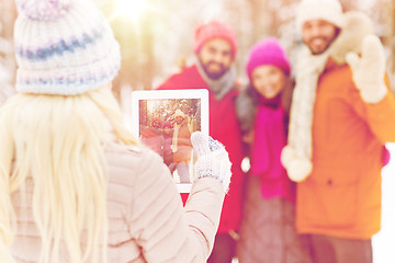 Image showing happy friends with tablet pc in winter forest