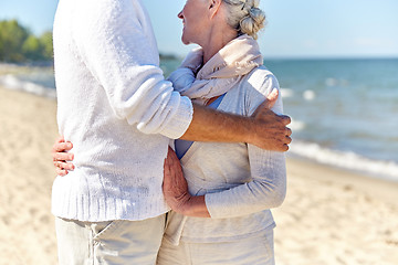 Image showing close up of happy senior couple hugging on beach