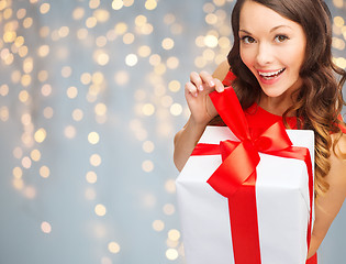 Image showing smiling woman in red dress with gift box