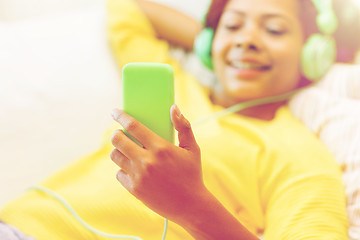 Image showing happy african woman with smartphone and headphones