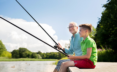 Image showing grandfather and grandson fishing on river berth