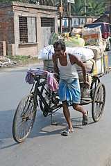 Image showing Man pushing heavily loaded cycle rickshaw through the streets of, Baruipur, India