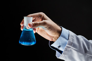 Image showing close up of scientist holding flask with chemical