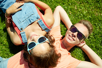 Image showing happy teenage couple lying on grass at summer
