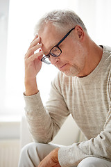 Image showing senior man suffering from headache at home