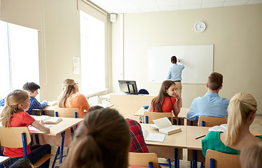 Image showing students and teacher writing on school white board