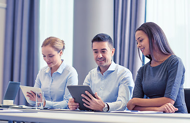 Image showing smiling business people with tablet pc in office