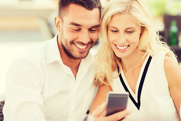 Image showing happy couple with smartphone at city street cafe
