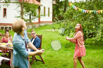 Image showing happy friends playing badminton at summer garden