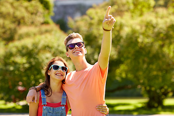 Image showing happy couple pointing finger at summer park