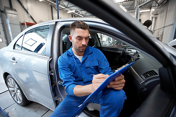 Image showing auto mechanic man with clipboard at car workshop