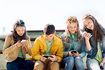 Image showing happy teenage friends with smartphones outdoors
