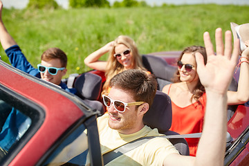 Image showing happy friends driving in cabriolet car at country