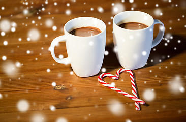 Image showing christmas candy canes and cups on wooden table