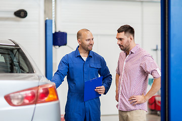 Image showing auto mechanic with clipboard and man at car shop