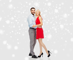 Image showing happy couple hugging over snow background