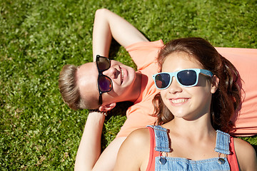 Image showing happy teenage couple lying on grass at summer