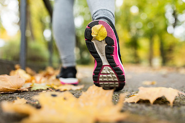 Image showing close up of young woman running in autumn park