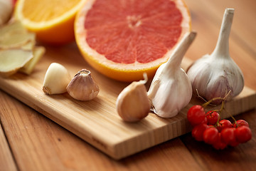 Image showing citrus, ginger, garlic and rowanberry on wood