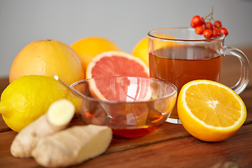 Image showing tea with honey, lemon and ginger on wood