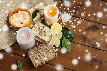 Image showing natural soap and body scrub with candles on wood