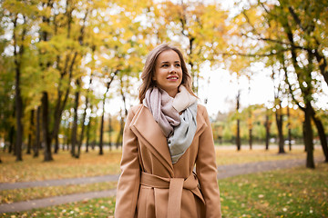 Image showing beautiful happy young woman walking in autumn park