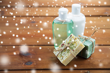 Image showing handmade soap bars and lotions on wood