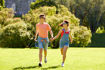 Image showing happy teenage couple running at summer park