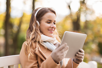 Image showing woman with tablet pc and headphones in autumn park