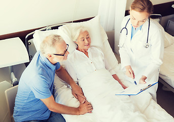 Image showing senior woman and doctor with clipboard at hospital