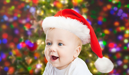 Image showing baby boy in christmas santa hat over blue lights