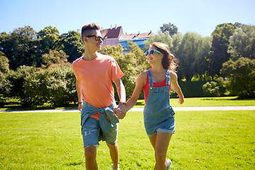 Image showing happy teenage couple walking at summer park