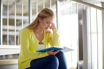 Image showing high school student girl reading book on stairs