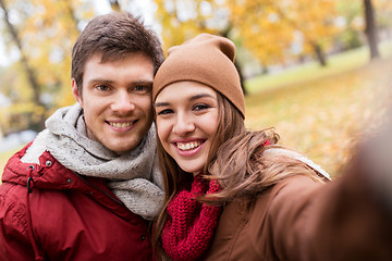 Image showing happy young couple taking selfie in autumn park