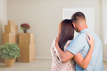 Image showing Military Couple Facing Empty Room with Packed Moving and Potted 