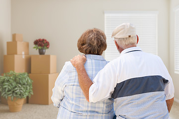 Image showing Senior Couple Facing Empty Room with Packed Moving Boxes and Pot