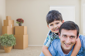 Image showing Father and Son in Room with Packed Moving Boxes and Potted Plant